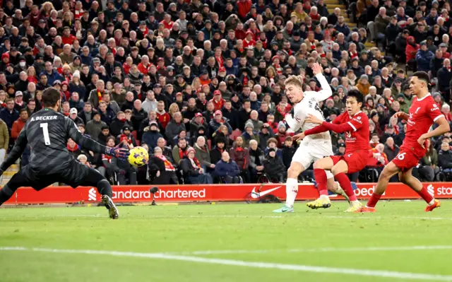 Liverpool goalkeeper Alisson Becker makes a save against Rasmus Hojlund of Manchester United