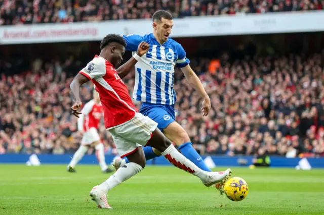 Bukayo Saka of Arsenal with Lewis Dunk of Brighton & Hove Albion