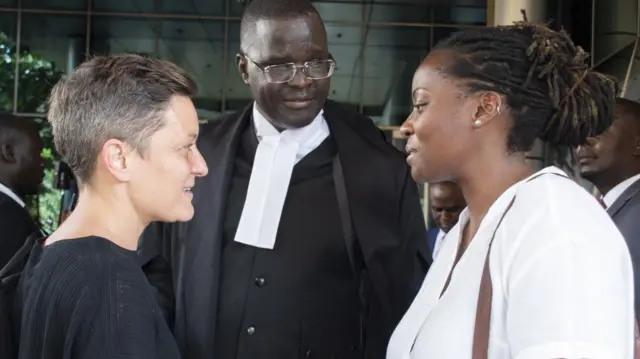 Ugandan human rights lawyer Nickolas Opiyo (C) speaks with Clare Byarugaba (R), an LGBTQ+ advocate from Ugandan civil liberties organisation Chapter Four, outside the Constitutional Court in Kampala, Uganda, 18 December 2023