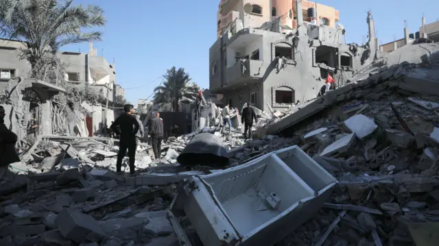 This file photo from 11 December shows Palestinians searching for victims and survivors among the rubble of destroyed houses on al-Maghazi refugee camp