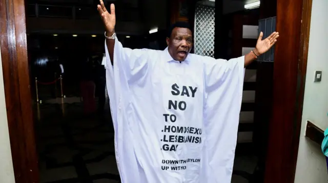 Member of Parliament from Bubulo contituency John Musira dressed in an anti gay gown gestures as he leaves the chambers during the debate of the Anti-Homosexuality bill, which proposes tough new penalties for same-sex relations during a sitting at the Parliament buildings in Kampala, Uganda March 21, 2023