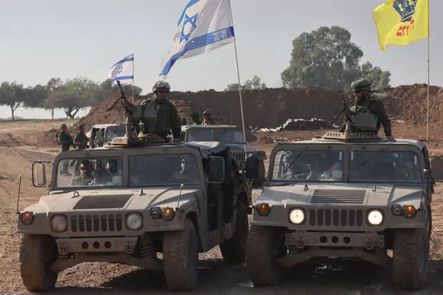 Israeli soldiers sit on their vehicles close to the Gaza border