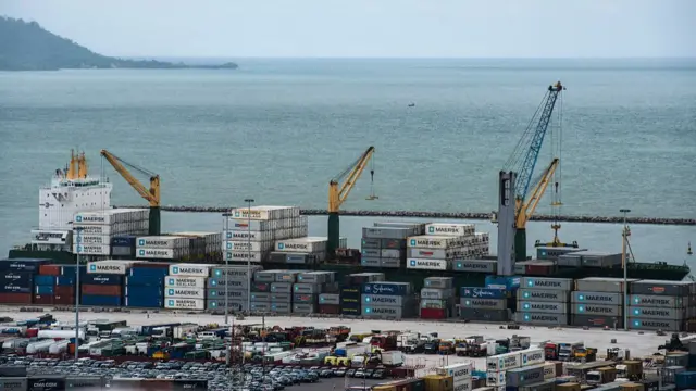 A container ship sits on the dockside during loading operations at the Port of Conakry in Conakry, Guinea, on Saturday, Sept. 5, 2015.