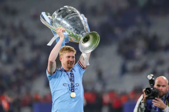 Kevin de Bruyne holds up the Champions League trophy