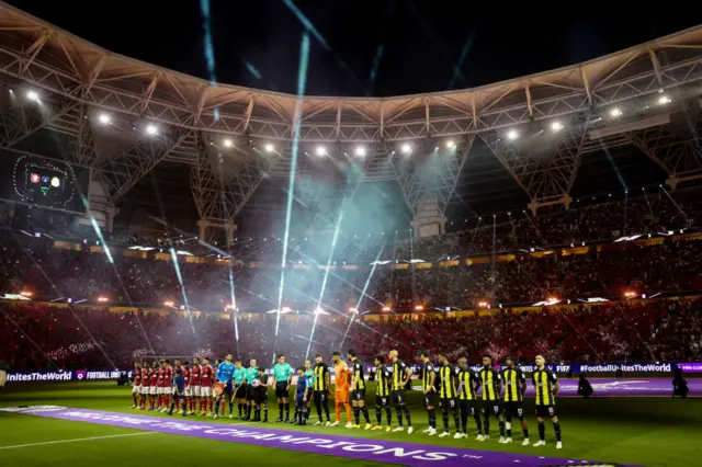 Al Ahly and Al-Ittihad line up on the pitch at King Abdullah Sports City