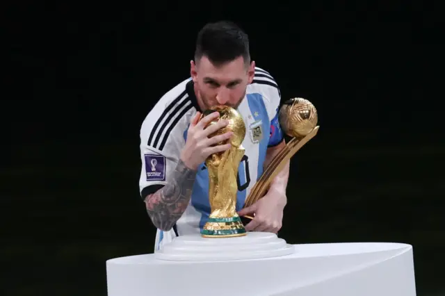 Lionel Messi kisses the World Cup trophy