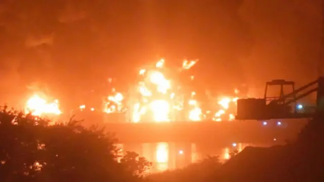 Fire burns after a blast at an oil terminal in Conakry, Guinea, December 18, 2023, in this screengrab obtained from a social media video.