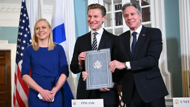 Finnish Foreign Minister Elina Valtonen and Defence Minister Antti Hakkanen with US Secretary of State Antony Blinken pose for a photo after signing an agreement