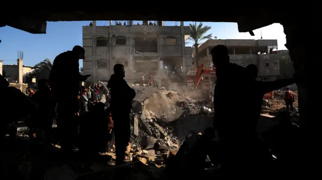 Palestinians search for causalities at the site of an Israeli strike on a house in Rafah, in the southern Gaza Strip