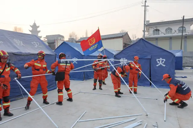 Workers setting up the blue tents in the early hours of Tuesday