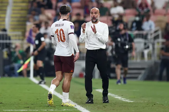 Pep Guardiola, Manager of Manchester City interacts with Jack Grealish on the touchline