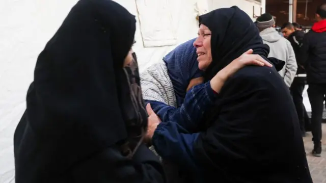 Palestinian women mourn in Rafah after an air strike hit a building overnight