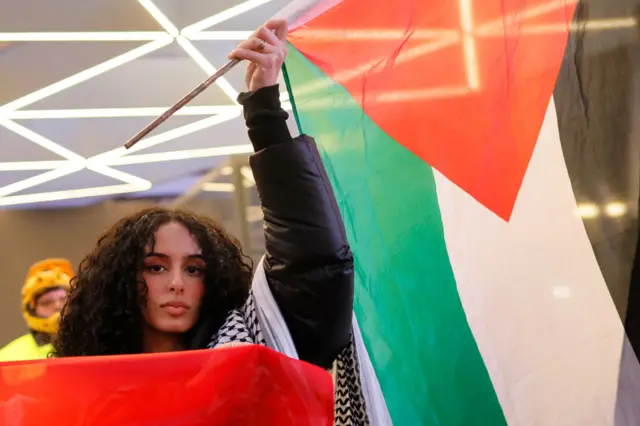 A protester waving a Palestinian flag