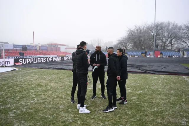 Officials looking at the pitch for Alfreton-Walsall