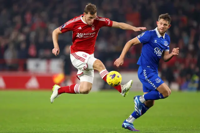 Wood controls the ball in mid air as he is marshalled by Tarkowski.