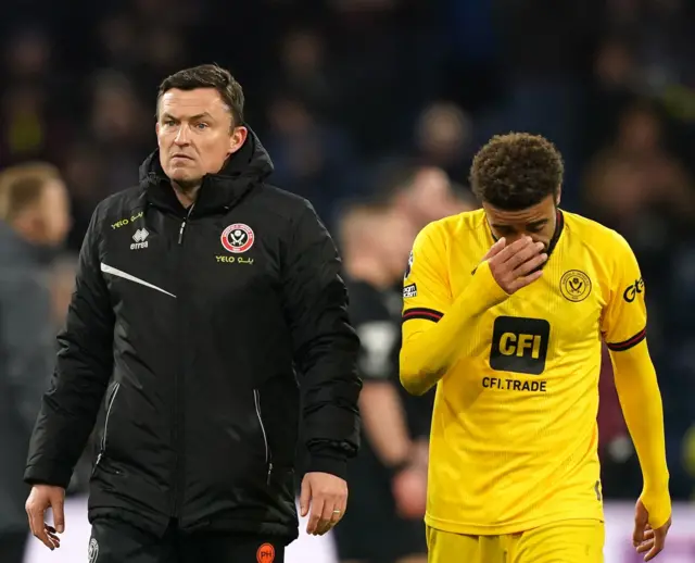 Paul Heckingbottom walks off the pitch alongside Jayden Bogle.