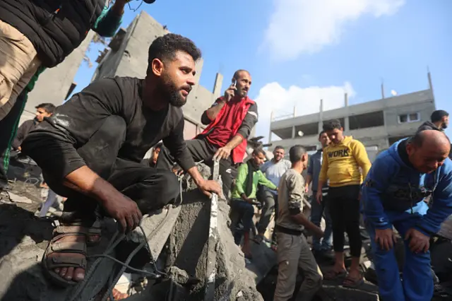 Palestinians inspect the damages of buildings destroyed in an Israeli strike on Khan Younis, 1 December 2023