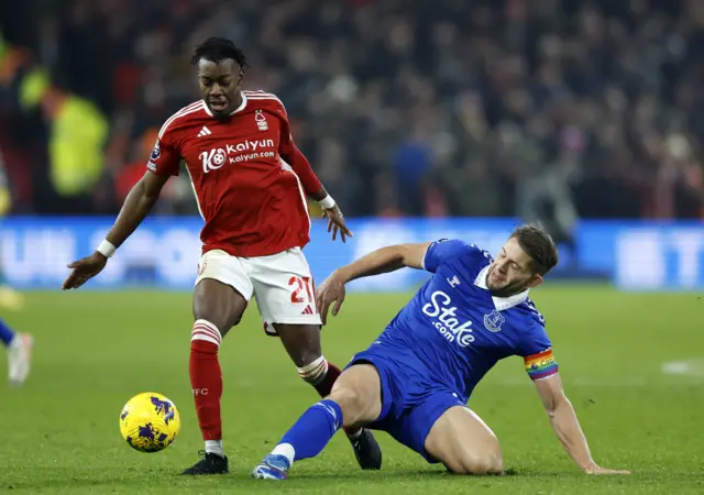 Elanga tries to break past the sliding challenge from Tarkowski.