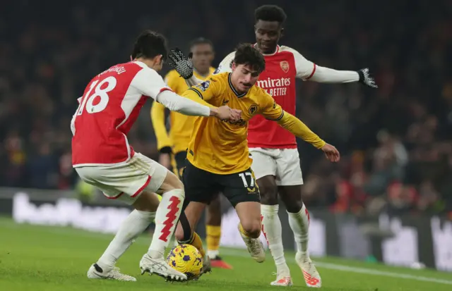 Bueno tries to dribble past Tomiyasu on the wing.