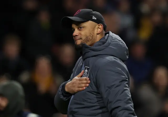 Kompany pats the Burnley club badge on his chest.