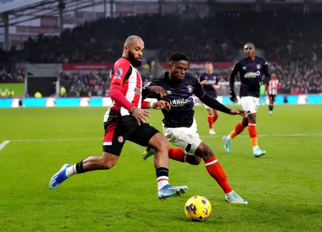 Mbeumo rusn down the wing with a Luton defender in pursuit.