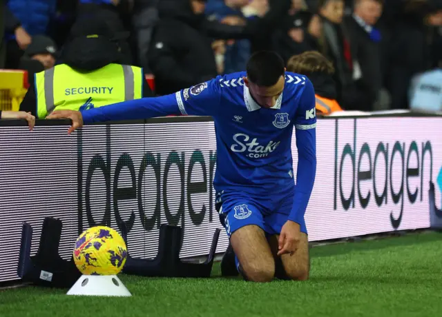 McNeil kneels and holds the advertising board after being knocked over.