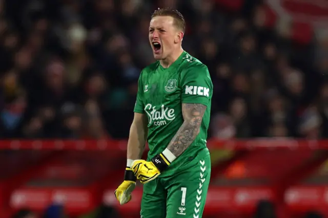 Pickford flexes his muscles and screams in delight.