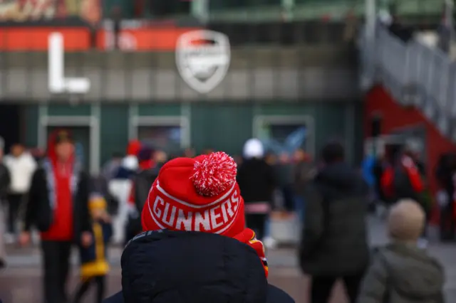 An Arsenal fan arrives at the ground in a 'Gunners' bobble hat.