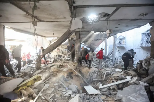 Palestinians in a building destroyed in an Israeli strike on Khan Yunis in the southern Gaza Strip, 1 December 2023