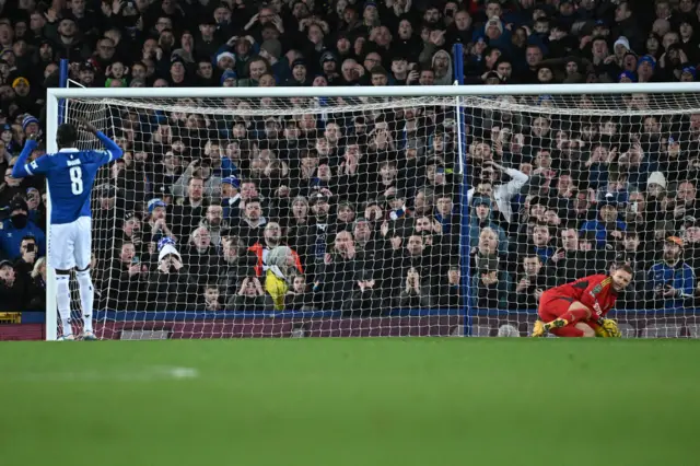 Fulham's German goalkeeper #17 Bernd Leno saves from Everton's Senegalese-born Belgian midfielder #08 Amadou Onana during a penalty shoot-out in the English League Cup quarter-final football match between Everton and Fulham at Goodison Park