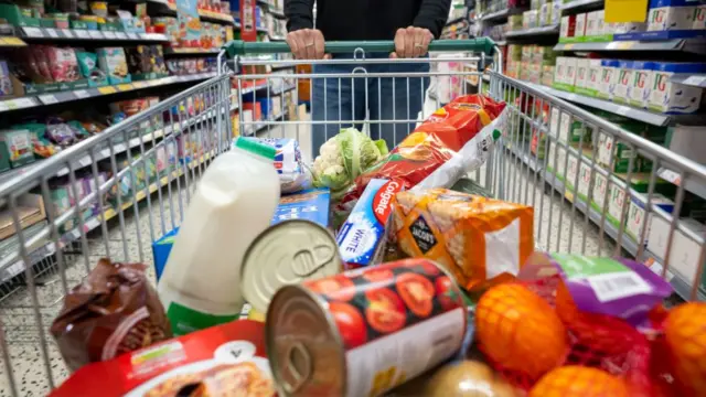 A woman with a shopping trolley full of groceries in a supermarket aisle on May 22, 2022 in Cardiff, Wales. Last week, the UK Office for National Statistics reported an 6% average increase of food and drink prices year on year, but some staples, such as milk and pasta, had risen by more than 10%.