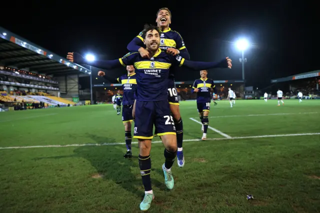 Matt Crooks of Middlesbrough celebrates with Morgan Rogers of Middlesbrough after scoring their 3rd goal during the Carabao Cup Quarter Final match between Port Vale and Middlesbrough at Vale Park on December 19, 2023 in Burslem, England.