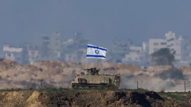 An Israeli military vehicle drives along the border with Gaza, amid the ongoing conflict between Israel and the Palestinian Islamist group Hamas, as seen from southern Israel, December 20, 2023.