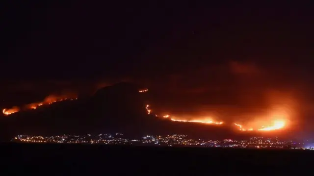 A view shows a fire over a mountain at Simon's Town as seen from Kalk Bay, in Cape Town, South Africa, December 19, 2023.