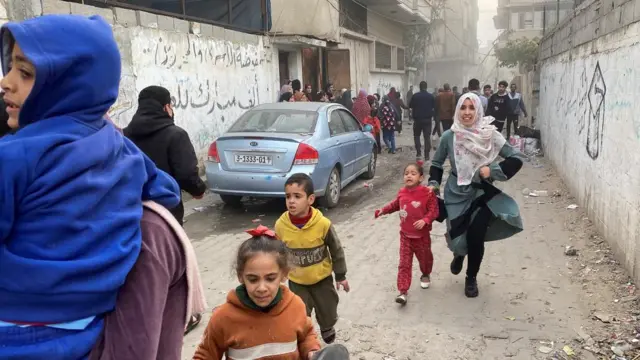 Rafah - woman and scared children running, after an Israeli airstrike, in Rafah, southern Gaza.