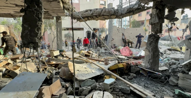 Palestinians gather at the site of an Israeli strike on a house