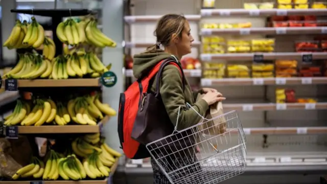 A customer shops for fruit at M and S supermarket in London