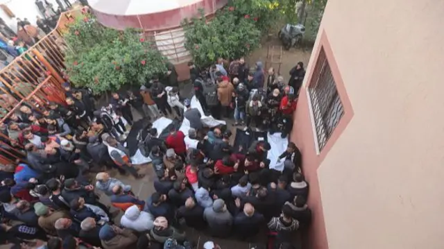 Relatives mourn as they receive dead bodies from the morgue of Nasser Hospital for burial in Khan Younis