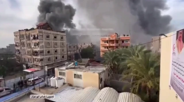 A still image taken from a roof. In the photo smoke can be seen rising from two at least locations