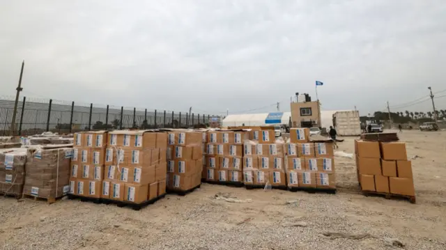 Boxes containing humanitarian aid are unloaded at the Karm Abu Salem (Kerem Shalom) crossing