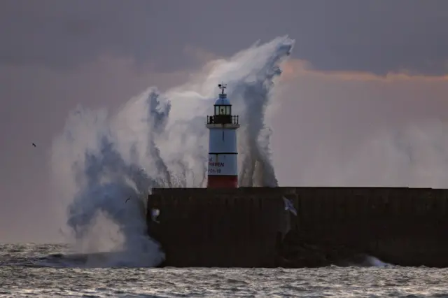 Waves crash over Newhaven breakwater and light house on December 21, 2023 in Newhaven, England