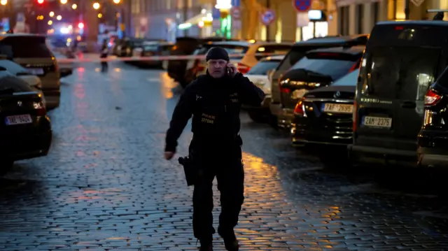 A police officer secures the area following the shooting at one of the buildings of Charles University in Prague,