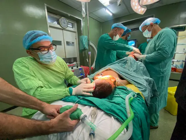 Health workers treat injured Palestinians including children, under difficult conditions at the Al-Ahli Hospital