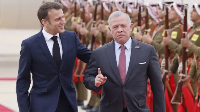 Jordan's King Abdullah II (R) welcomes France's President Emmanuel Macron (L) upon his arrival at Aqaba airport on December 21, 2023, during a two-day visit to Jordan