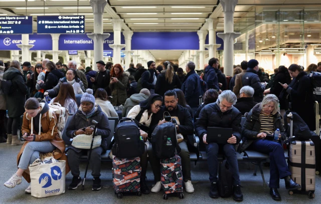 Commuters sit at St Pancras