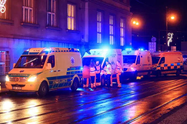 Members of the emergency service at the scene of a shooting prepare to help the dozens of injured