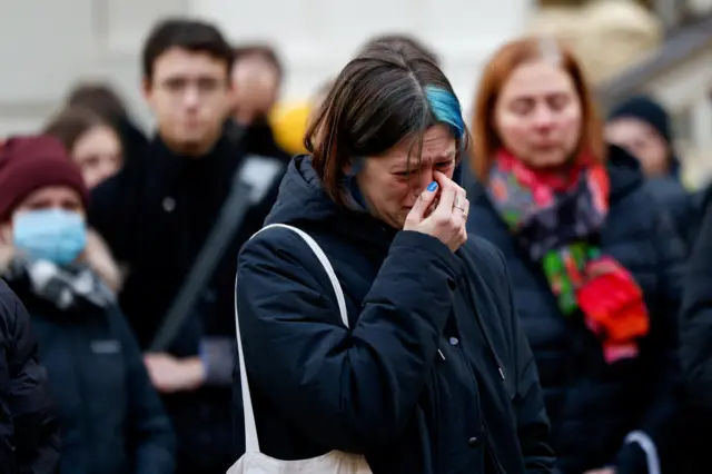 Woman reacts at a memorial during a vigil following a shooting at one of Charles University's buildings in Prague, 22 December 2023