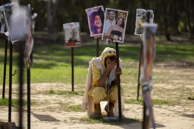 A man grieving by some photographs