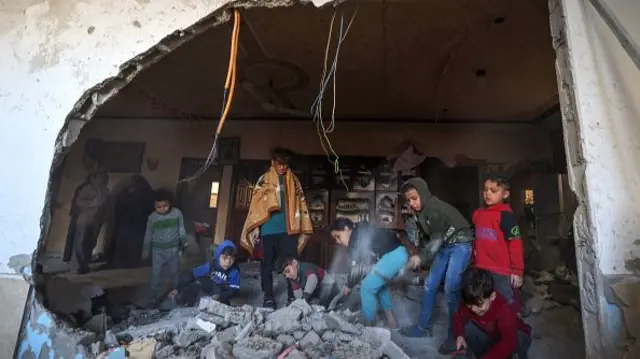 Palestinian children check debris following Israeli bombardment in Rafah in the southern Gaza Strip amid continuing battles between Israel and the militant group Hamas