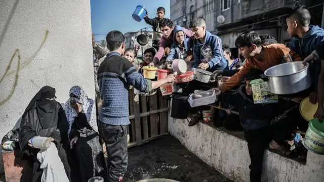 Palestinians receive food and humanitarian aid as Israeli airstrikes continue in Rafah, Gaza